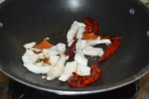 Coconut and red chilies getting roasted in oil